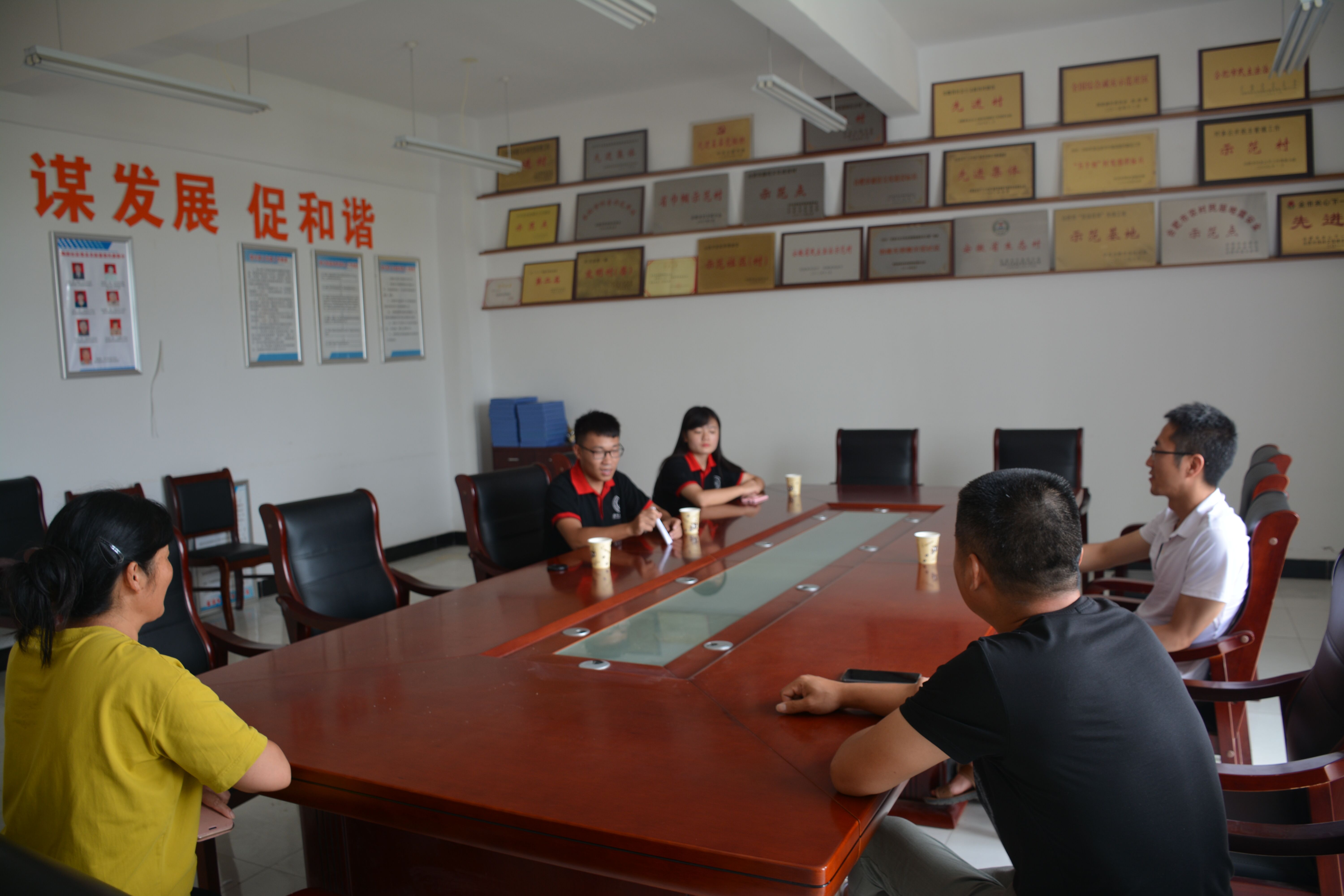 （志愿者在参观社区后和村委会负责人进行洽谈）.jpg