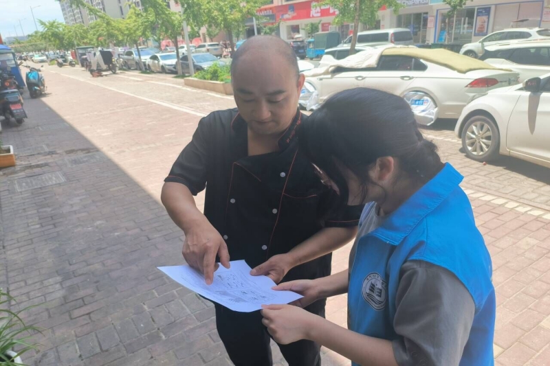 图为“慧火童心”实践团向社区居民宣传消防知识.jpg