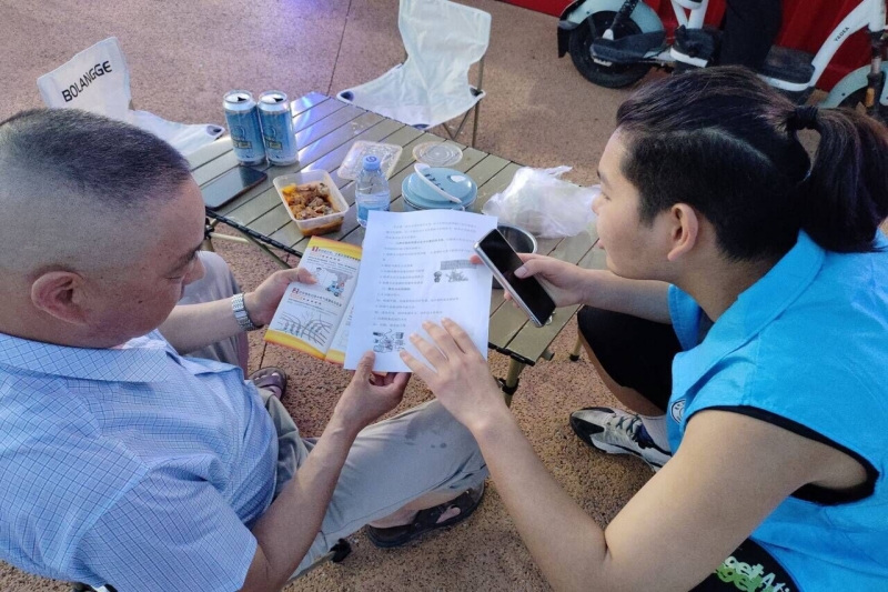 图为实践团成员向老人讲解灭火器使用方法.jpg