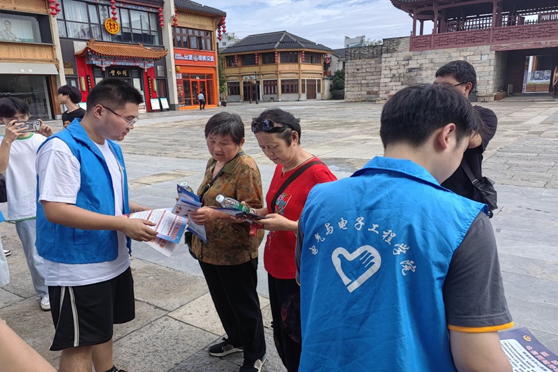 图为志愿者向社区老人宣传防火防溺水知识.jpg