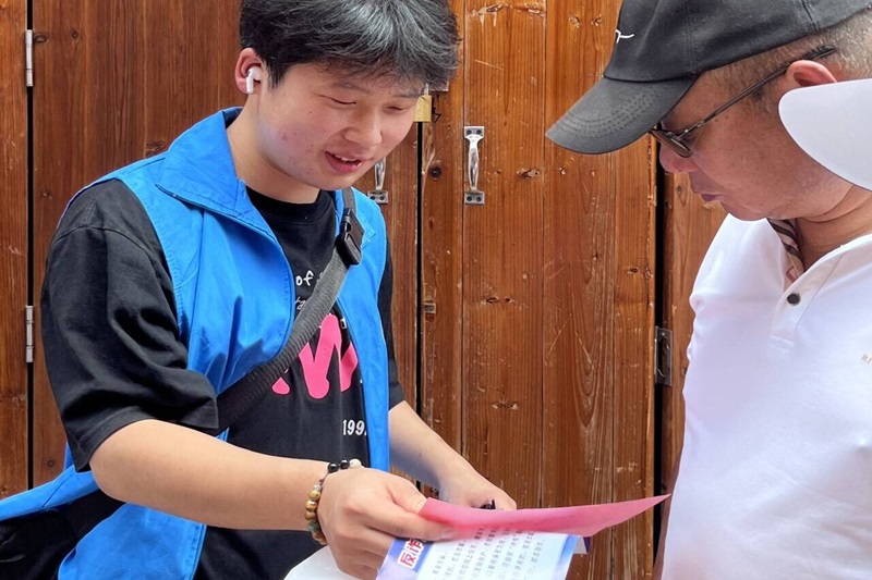 图为志愿者向社区居民宣讲防诈骗知识.jpg