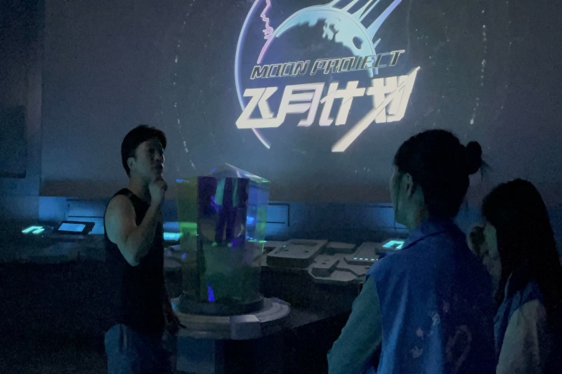 图为工作人员向成员们讲解月球基地总控室.jpg