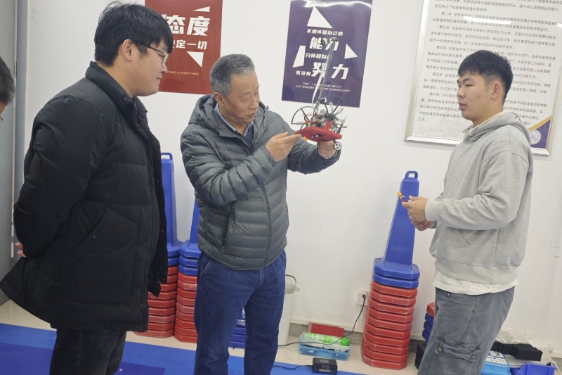 图为吴敏观摩学生调试智能车情况.jpg