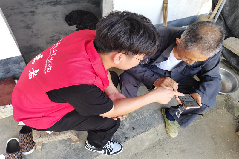 图3志愿者帮助泾县丁桥村老兵丁善炉解决手机使用问题_副本.jpg