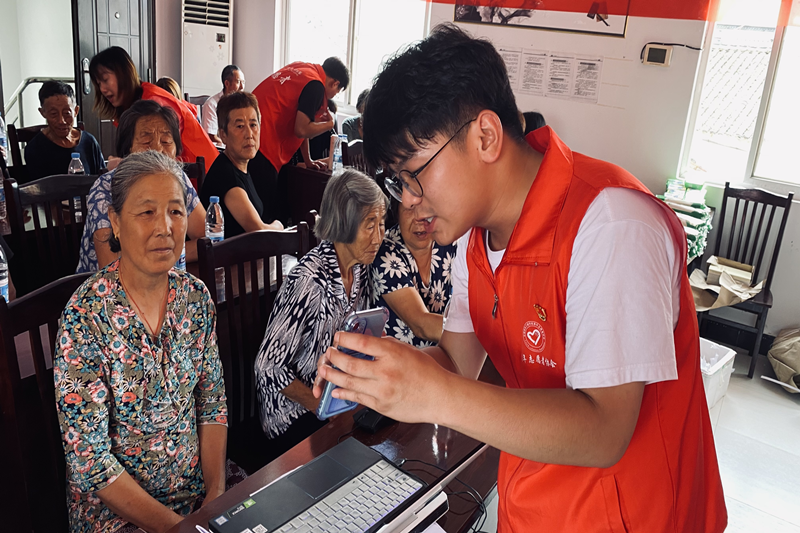 图9志愿者给老人讲解如何使用支付宝以及安康码_副本.png