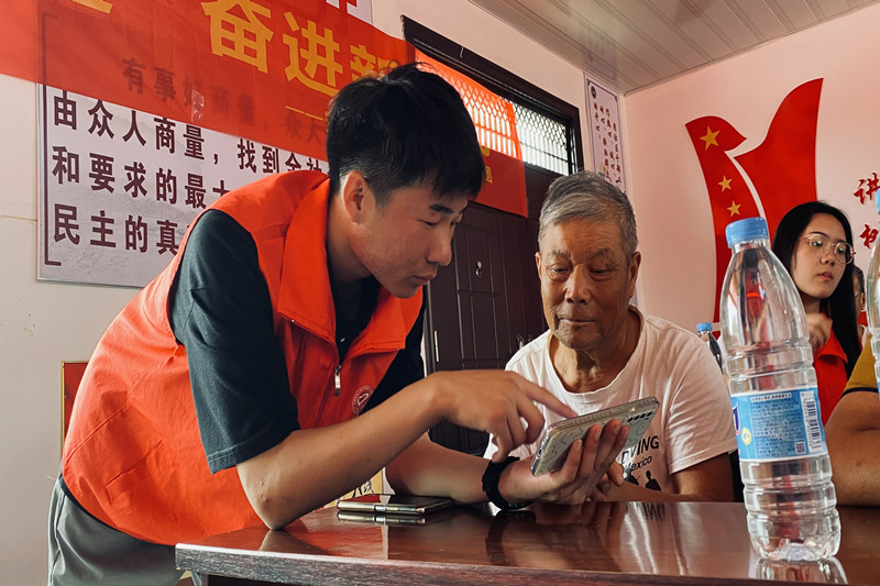 图12志愿者一对一帮助老人解决手机使用问题_副本.jpg