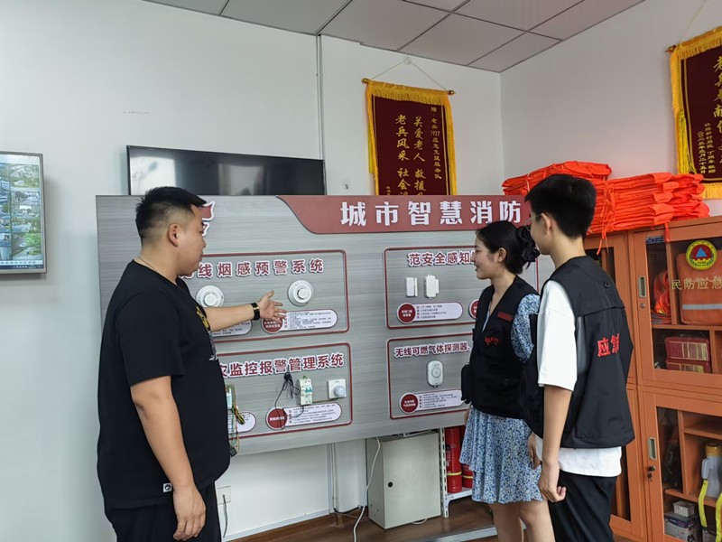 图为专业人士向志愿者介绍智慧消防系统.jpg