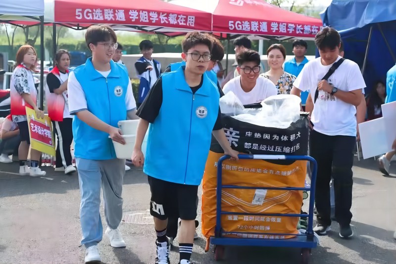 图为志愿者帮助新生搬行李.jpg